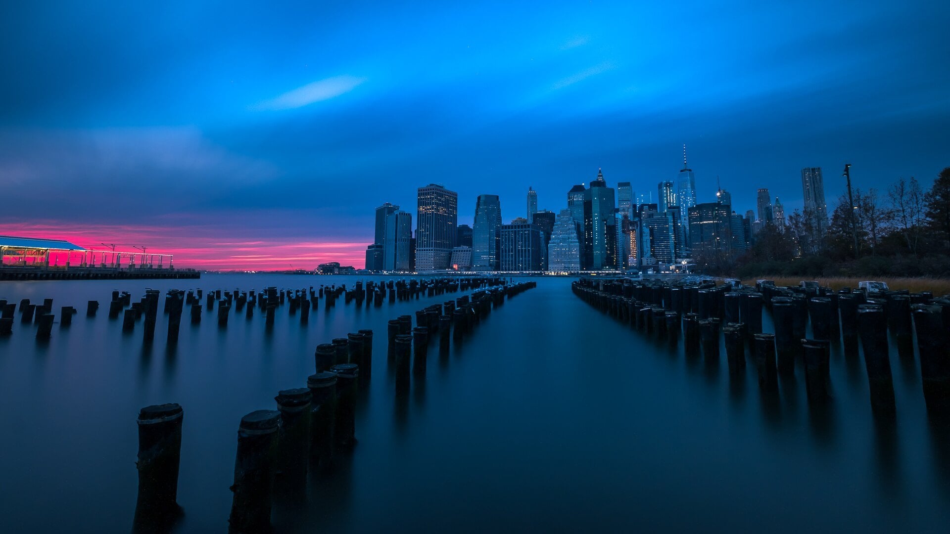 Lower Manhattan skyline at dusk seen across the old Hudson River piers